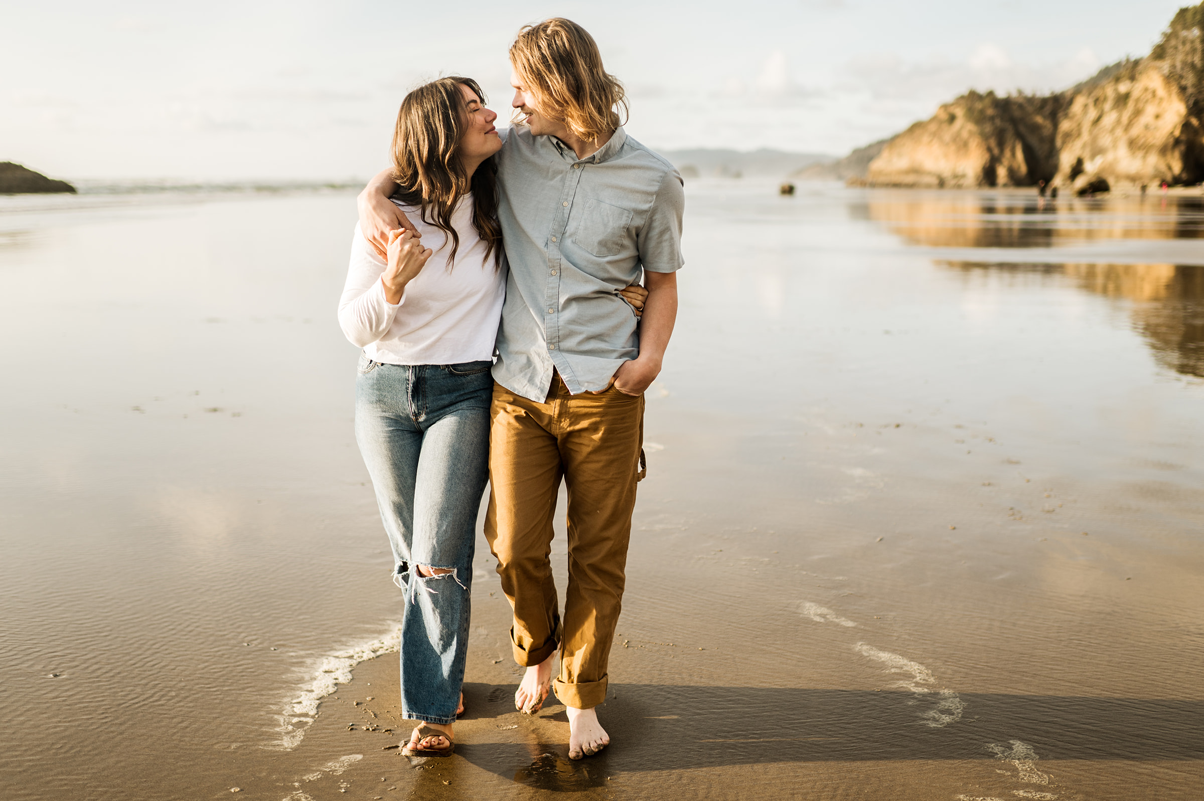 engaged couple walks along oregon coast beach, hug point state park