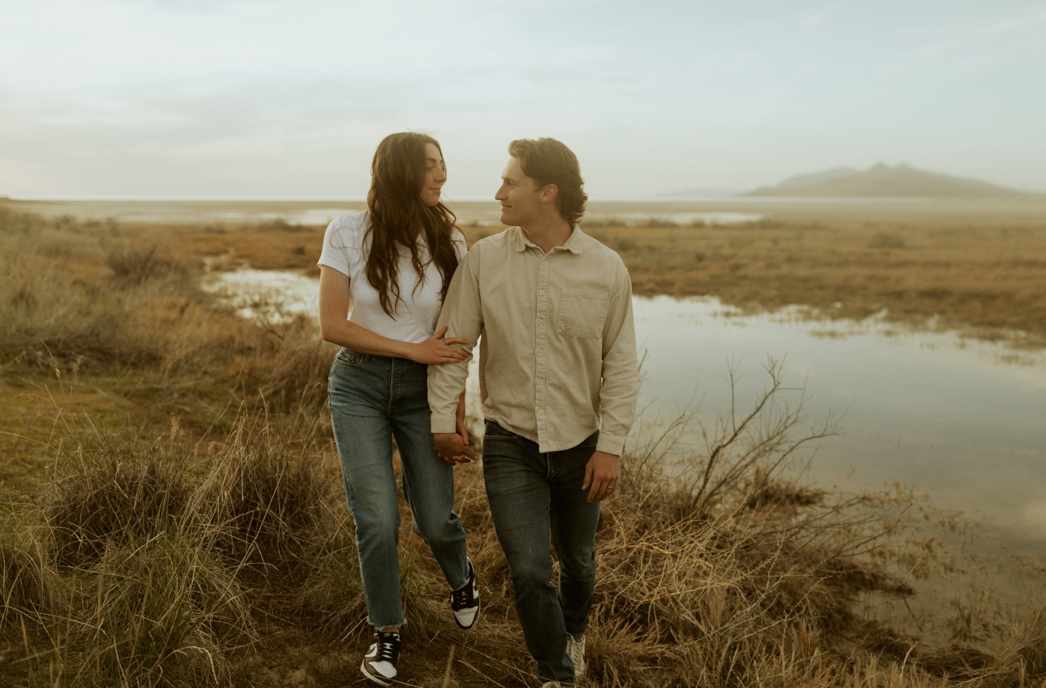 Couple taking Utah Anniversary Photos in front of water and tall grass. 