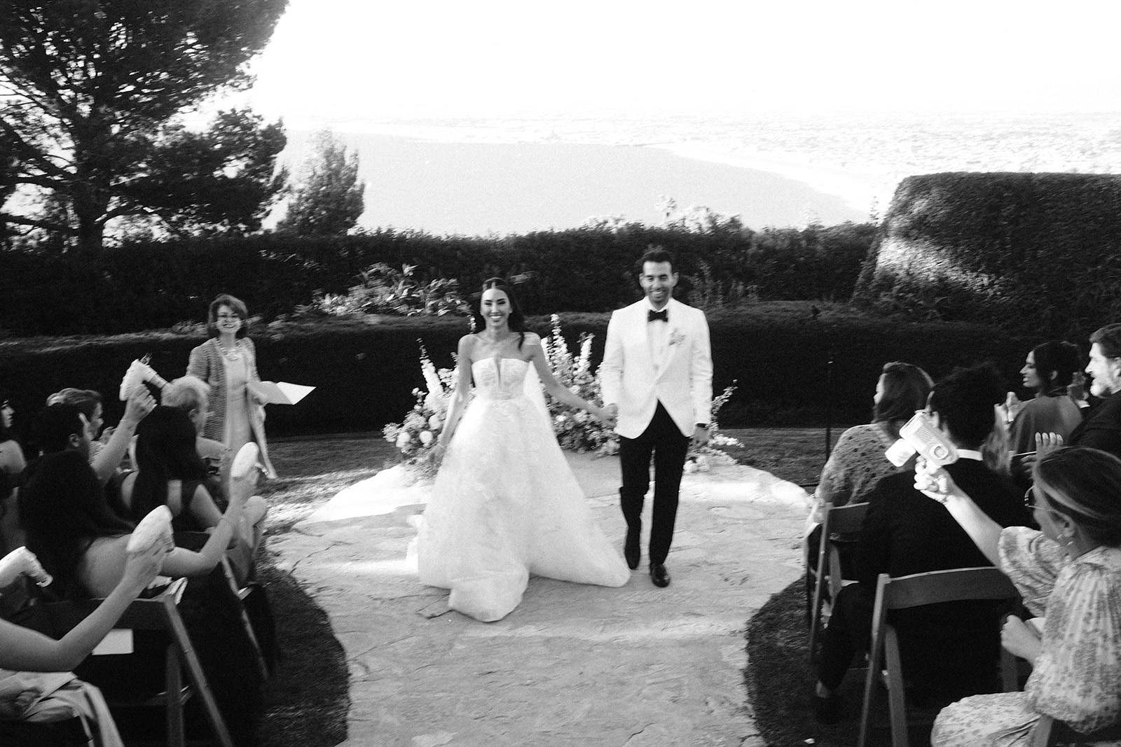 A couple walks down the aisle on wedding day at beautiful venue in Palos Verdes, California 