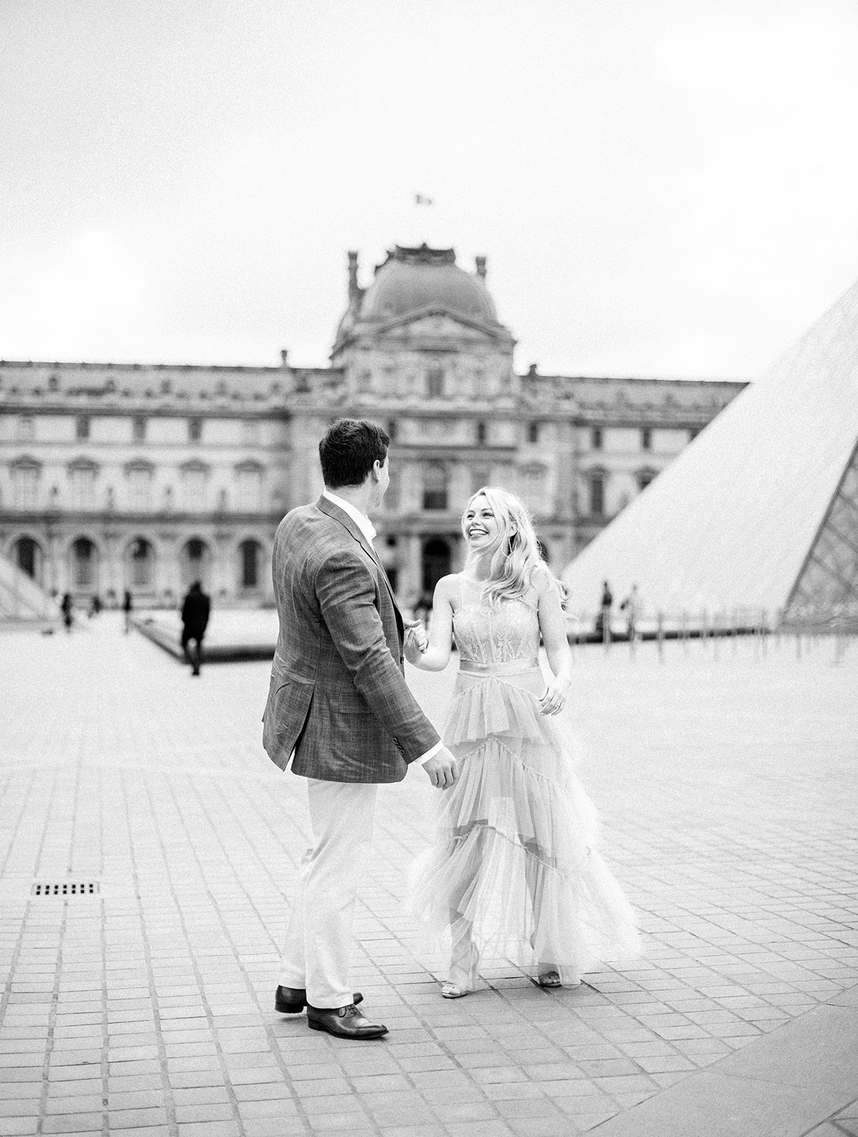 Couple holding hands outside of Louvre