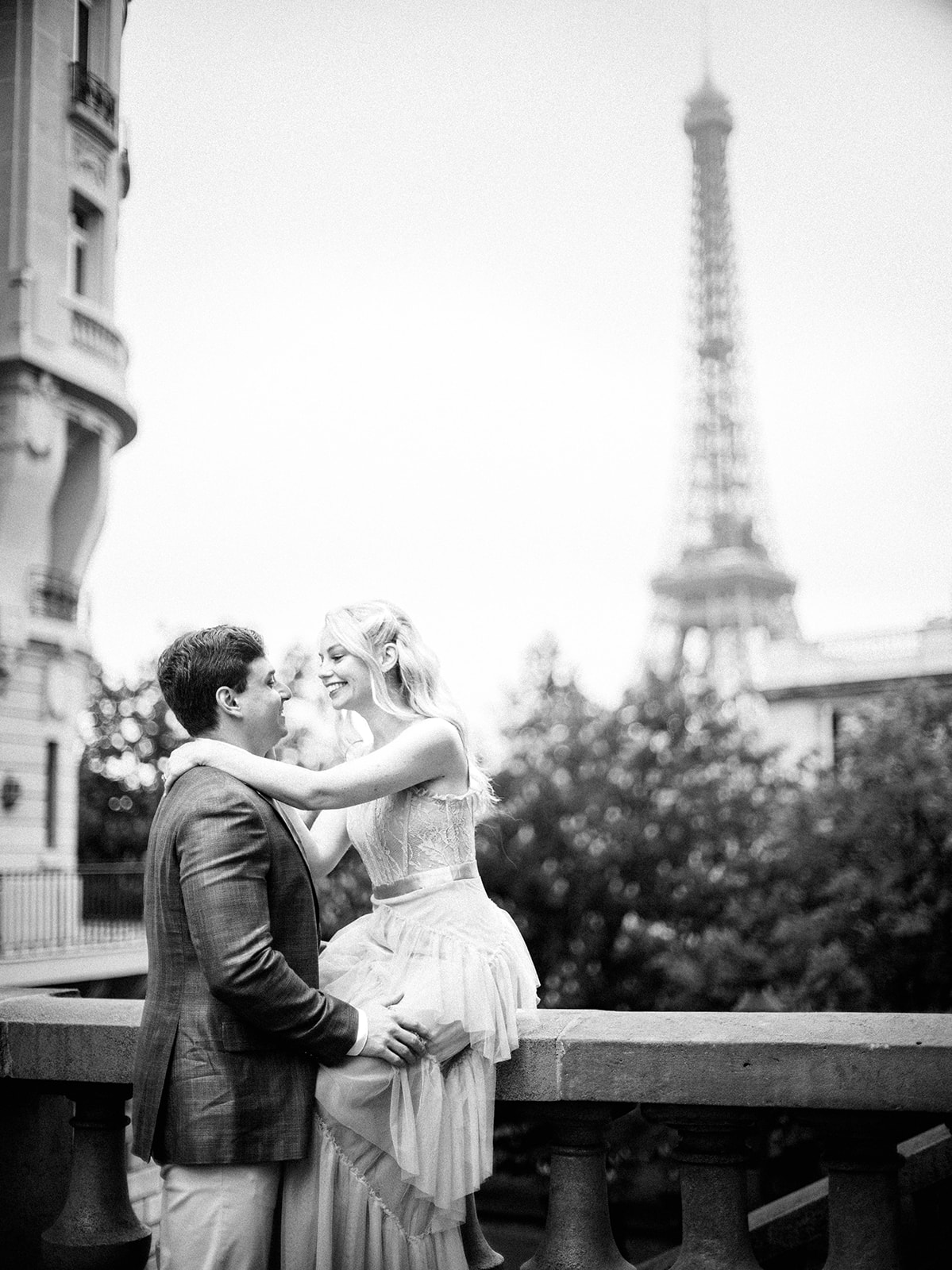 Couple sits with the Eiffel Tower in the background.
