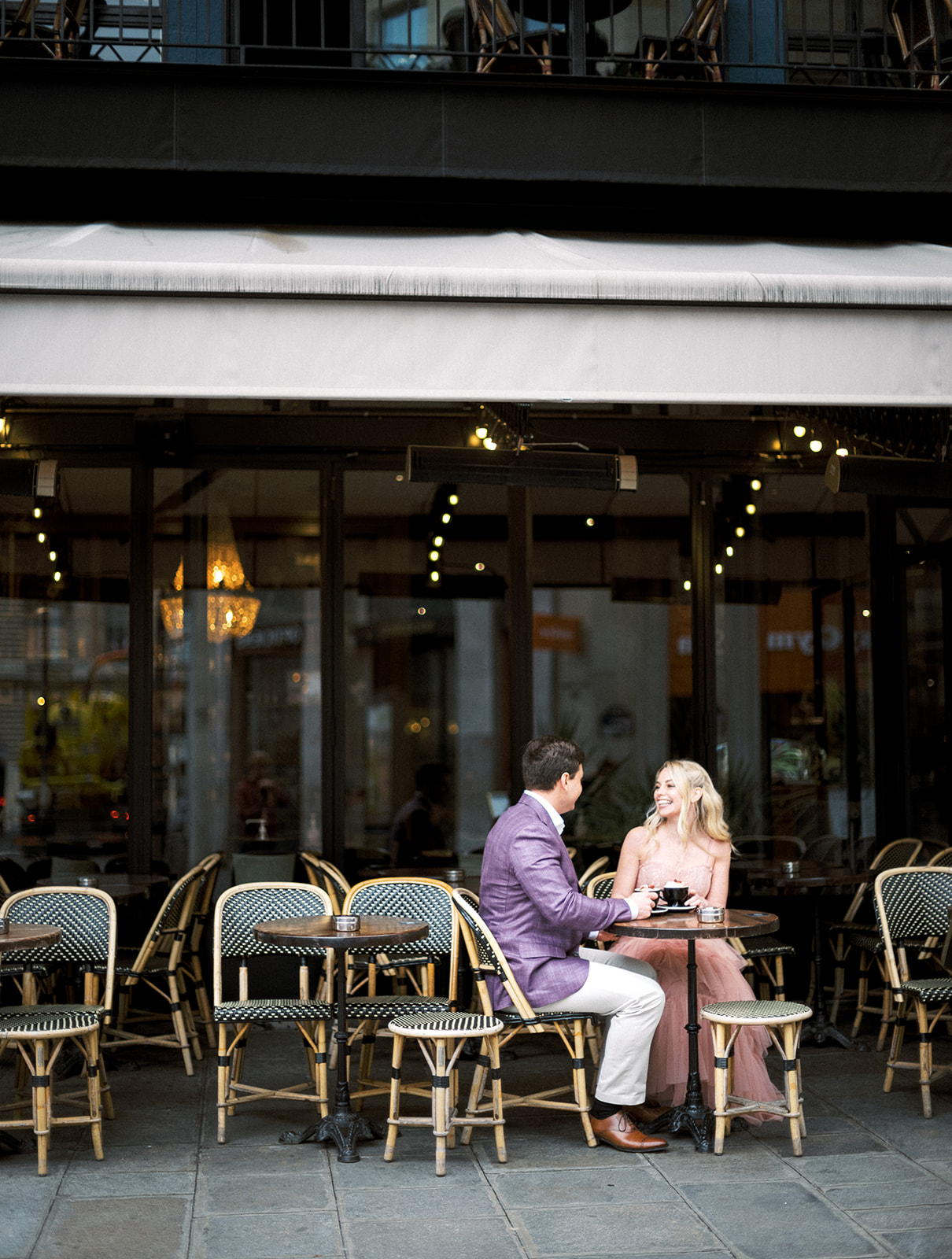 Couple sitting outside of cafe in Paris.