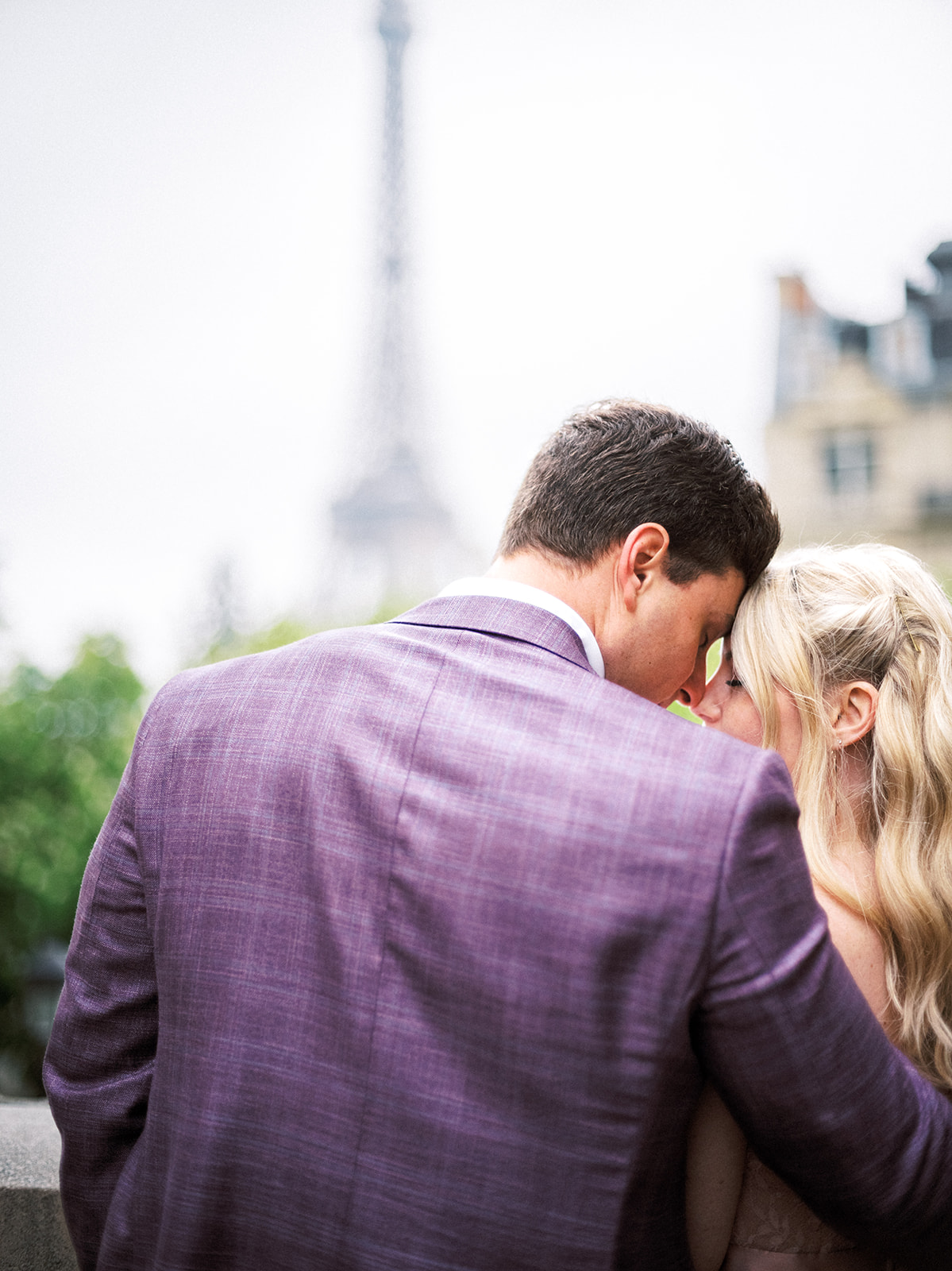 Couple touching foreheads with Eiffel Tower in the background.