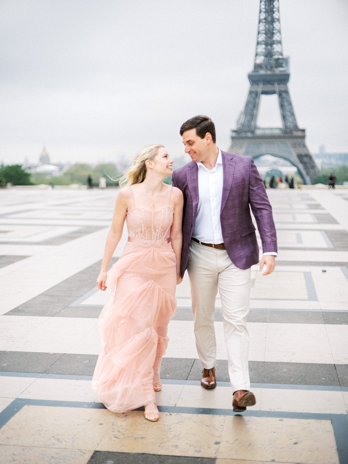 Couple walking away from Eiffel Tower.