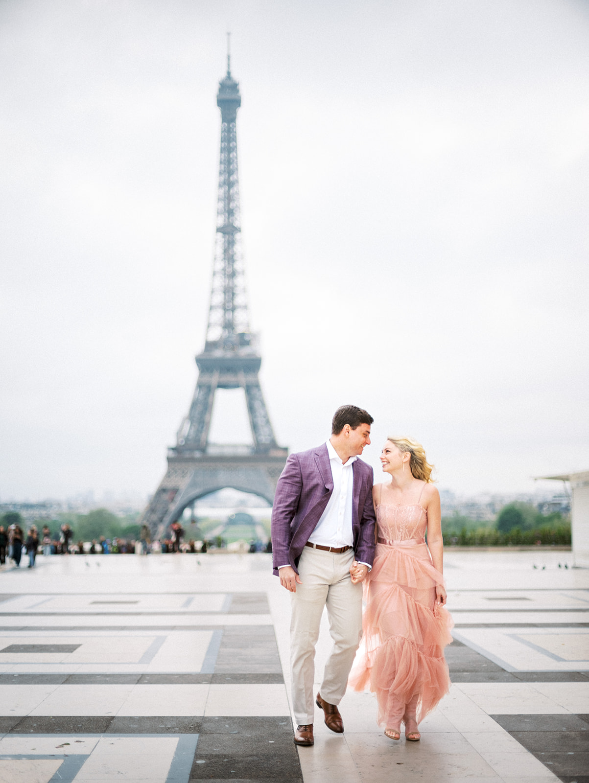 Couple walking away from the Eiffel Tower.