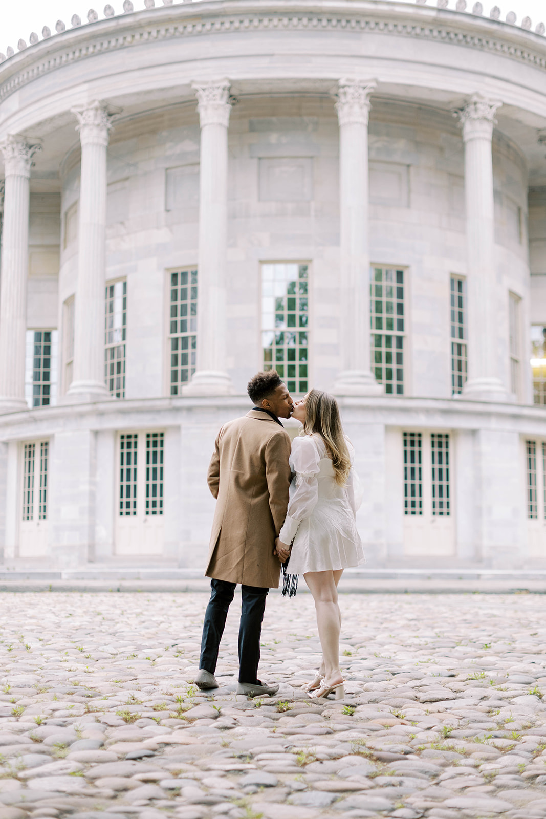 Couple kisses in front of the iconic merchants exchange building in Philadelphia, PA.