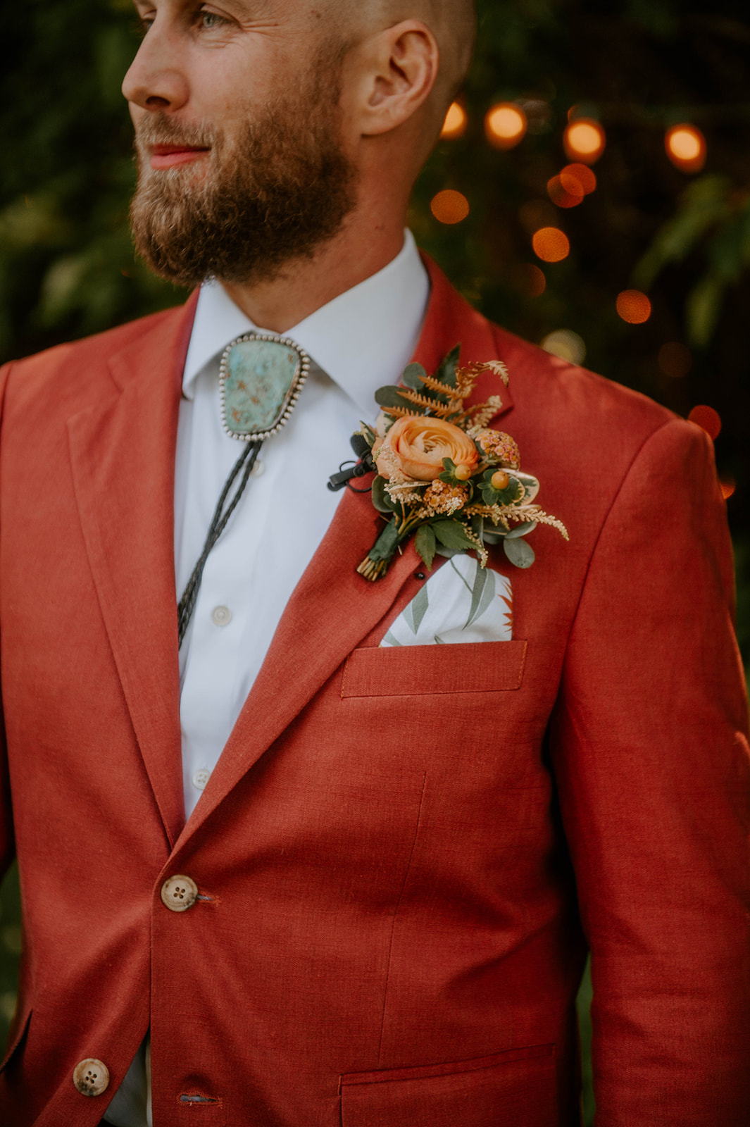 groom with turquoise bolo tie and orange suite