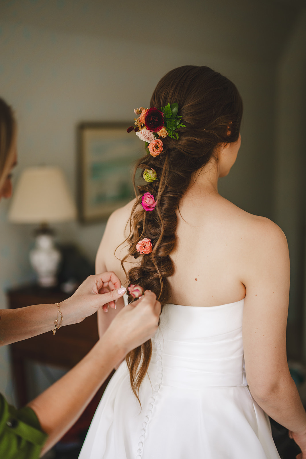 a bride has flowers attached to her hair braid