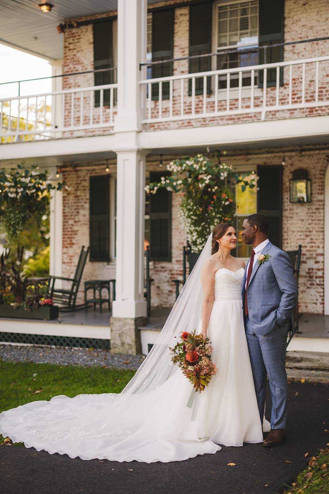 a bride and groom pose together in front of the historic Grafton Inn in Grafton Vermont