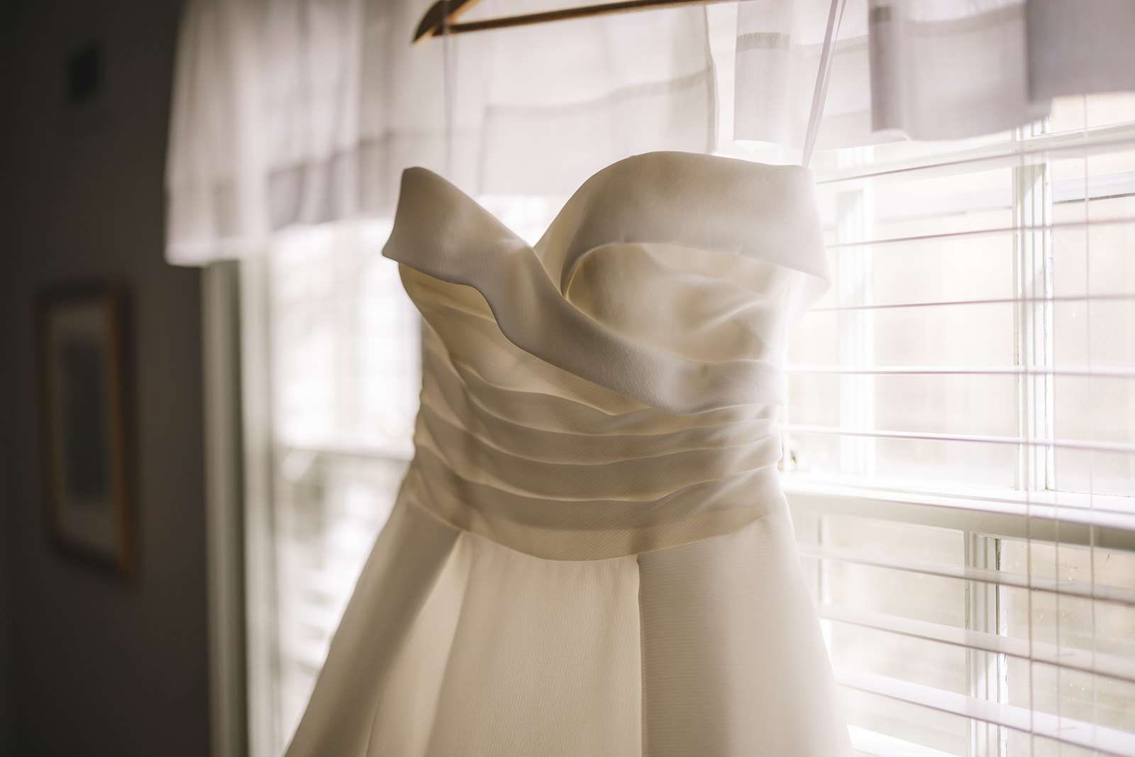 a wedding dress hangs in the window of the white gates house at the Grafton Inn