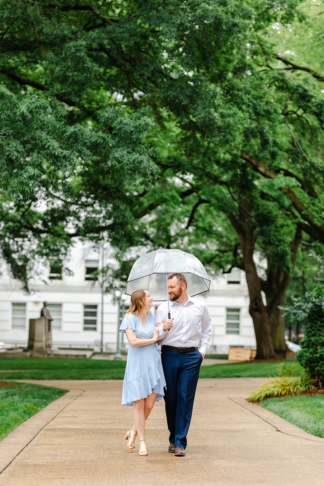 Couple walking in Downtown Raleigh with bubble umbrellas in the rain