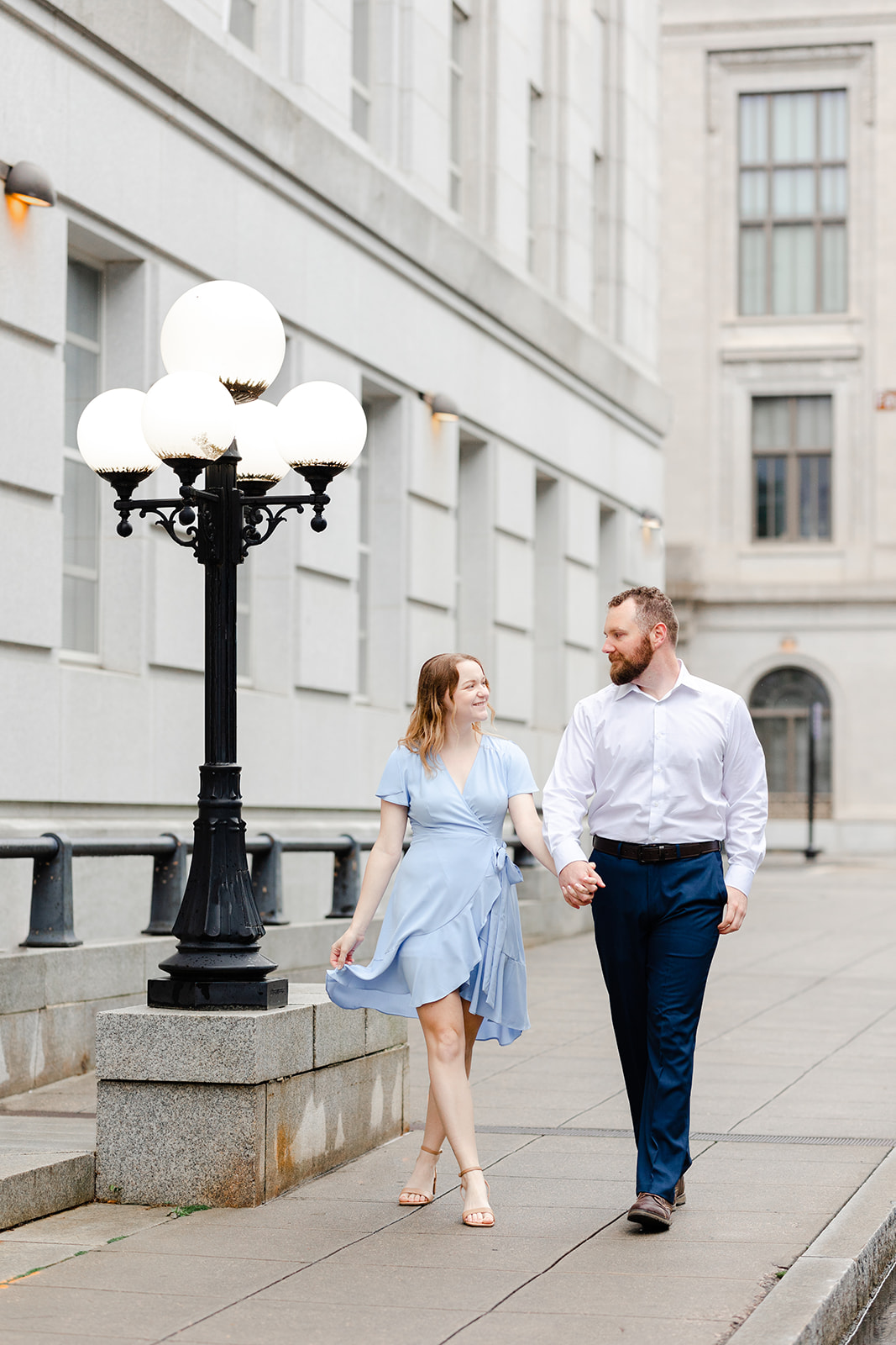Couple walking in urban downtown engagement session in Downtown Raleigh