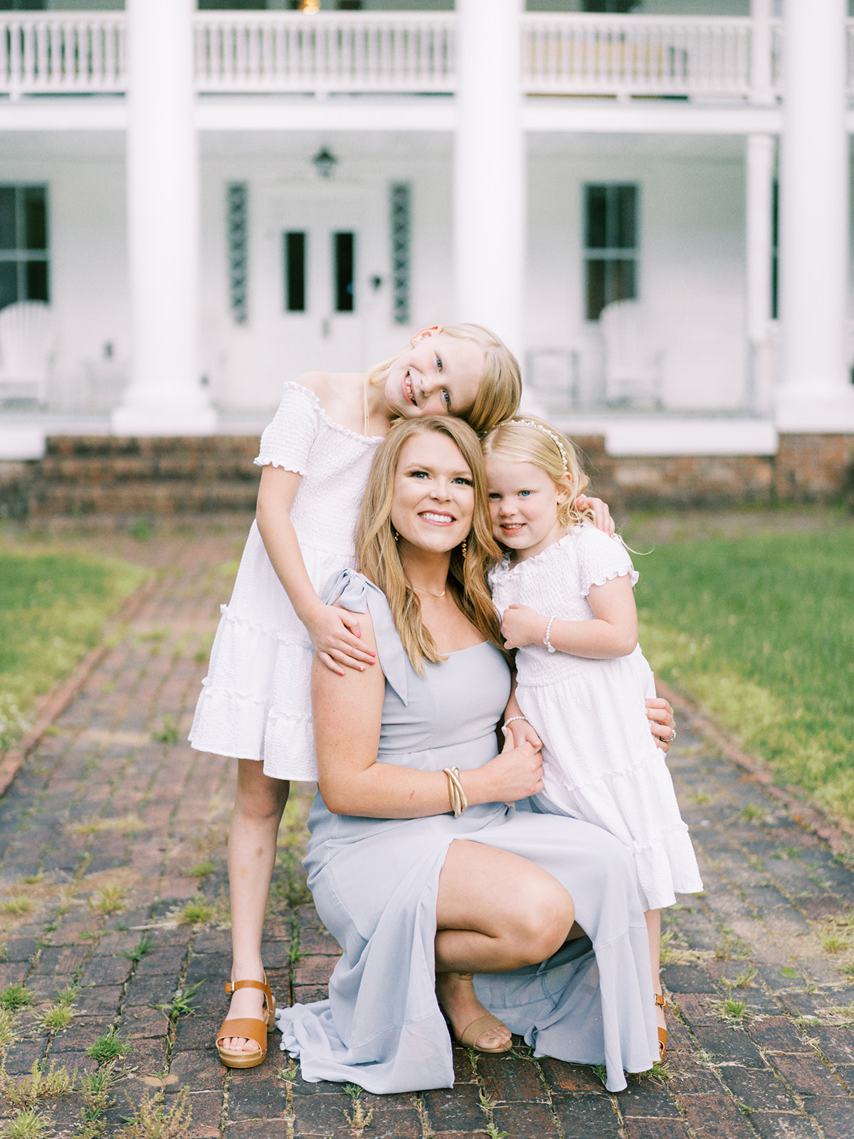 A mother and her daughters pose in front of the Winston Place in Valley Head, Alabama
