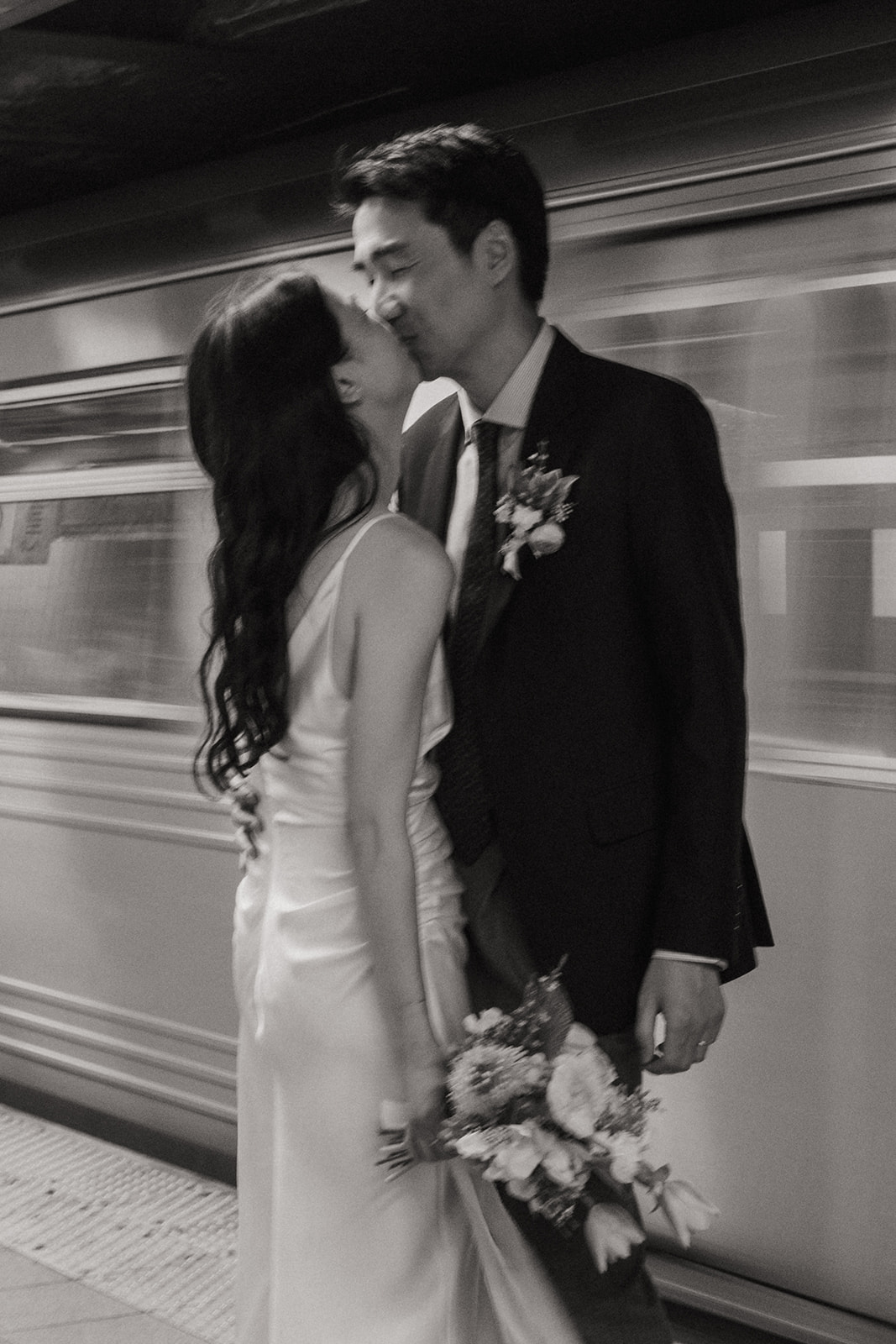 nyc bride and groom kissing in the subway