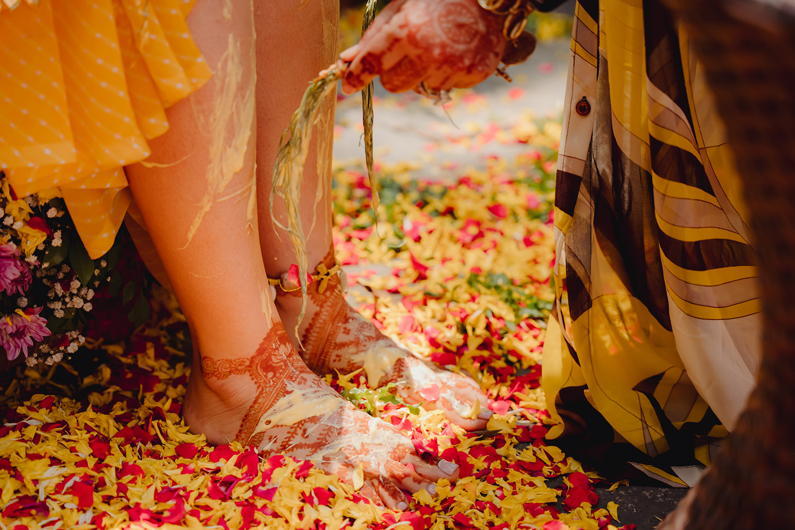 Cultural ritual: Capturing the moment as haldi is applied to the bride's graceful legs