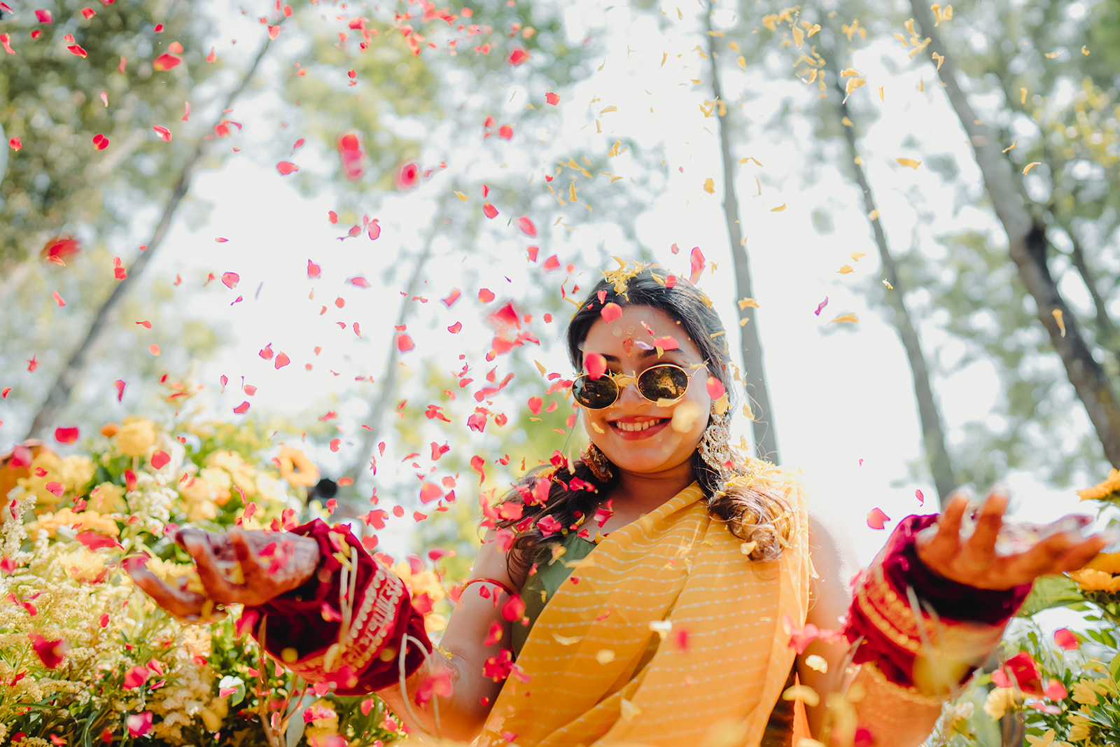 Capturing the magic: Bride enveloped in a cascade of fragrant rose petals