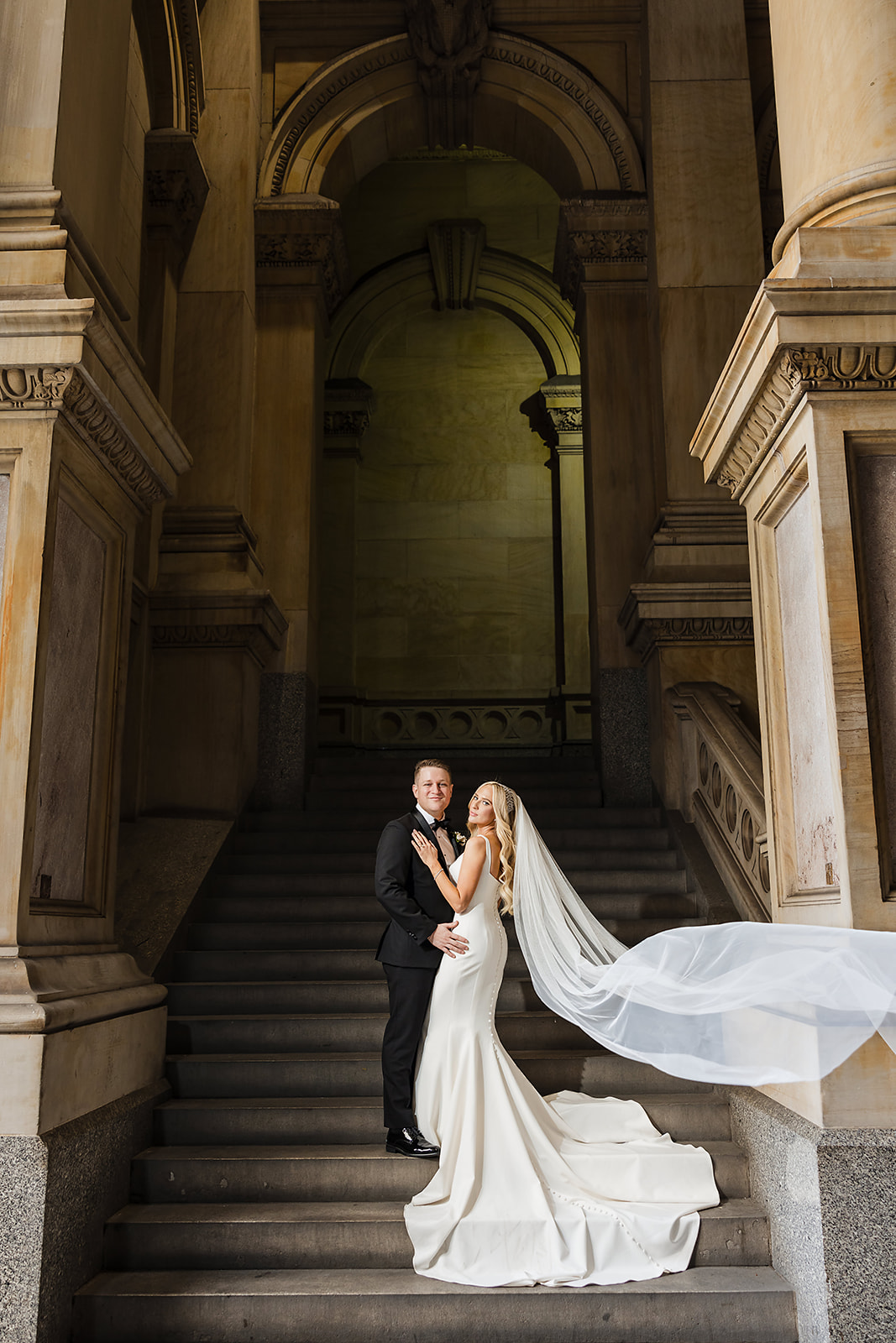 City hall Philadelphia wedding photo of the bride and groom with flowing veil on the steps 