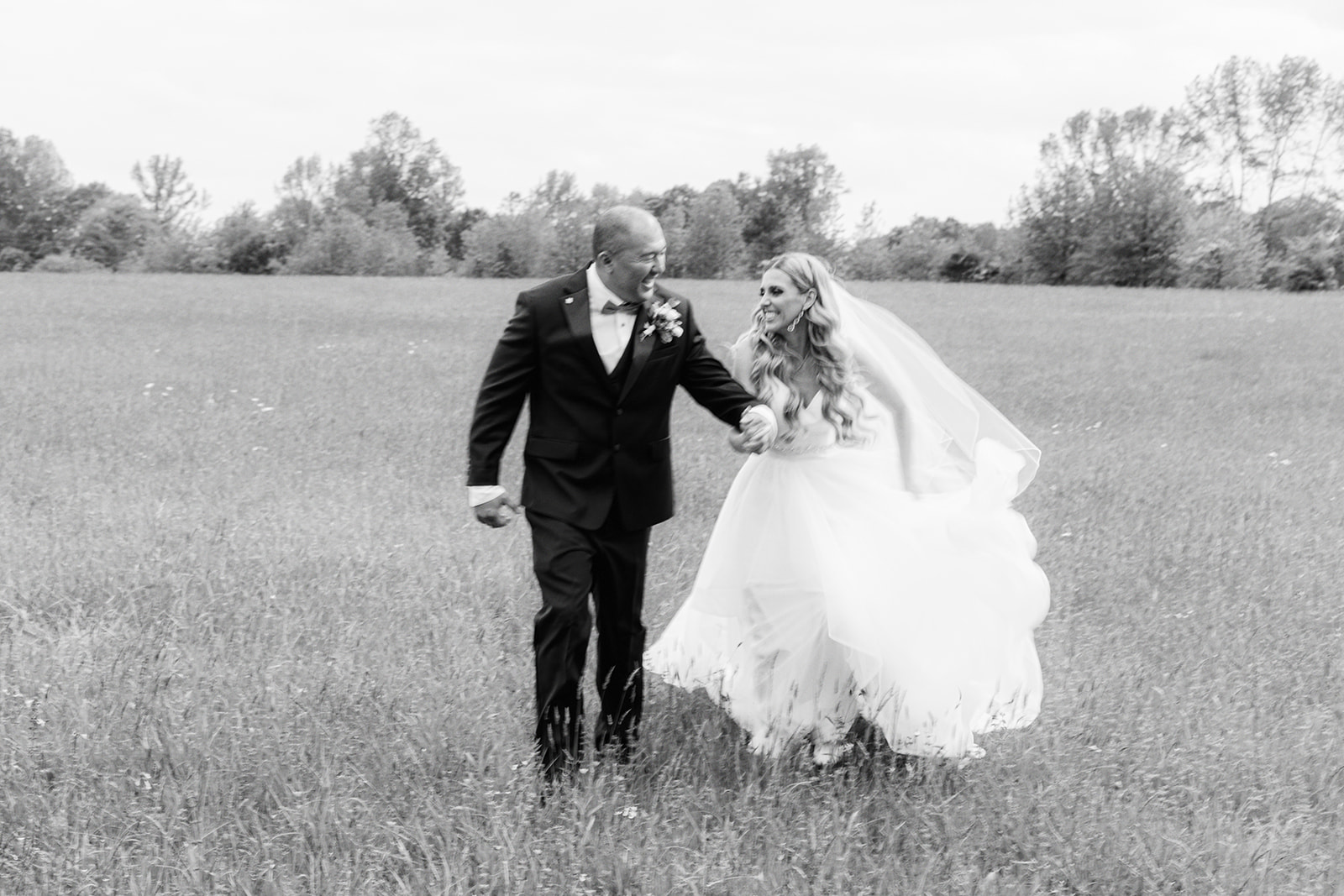 The bride and groom run through an open field in Mentone, Alabama