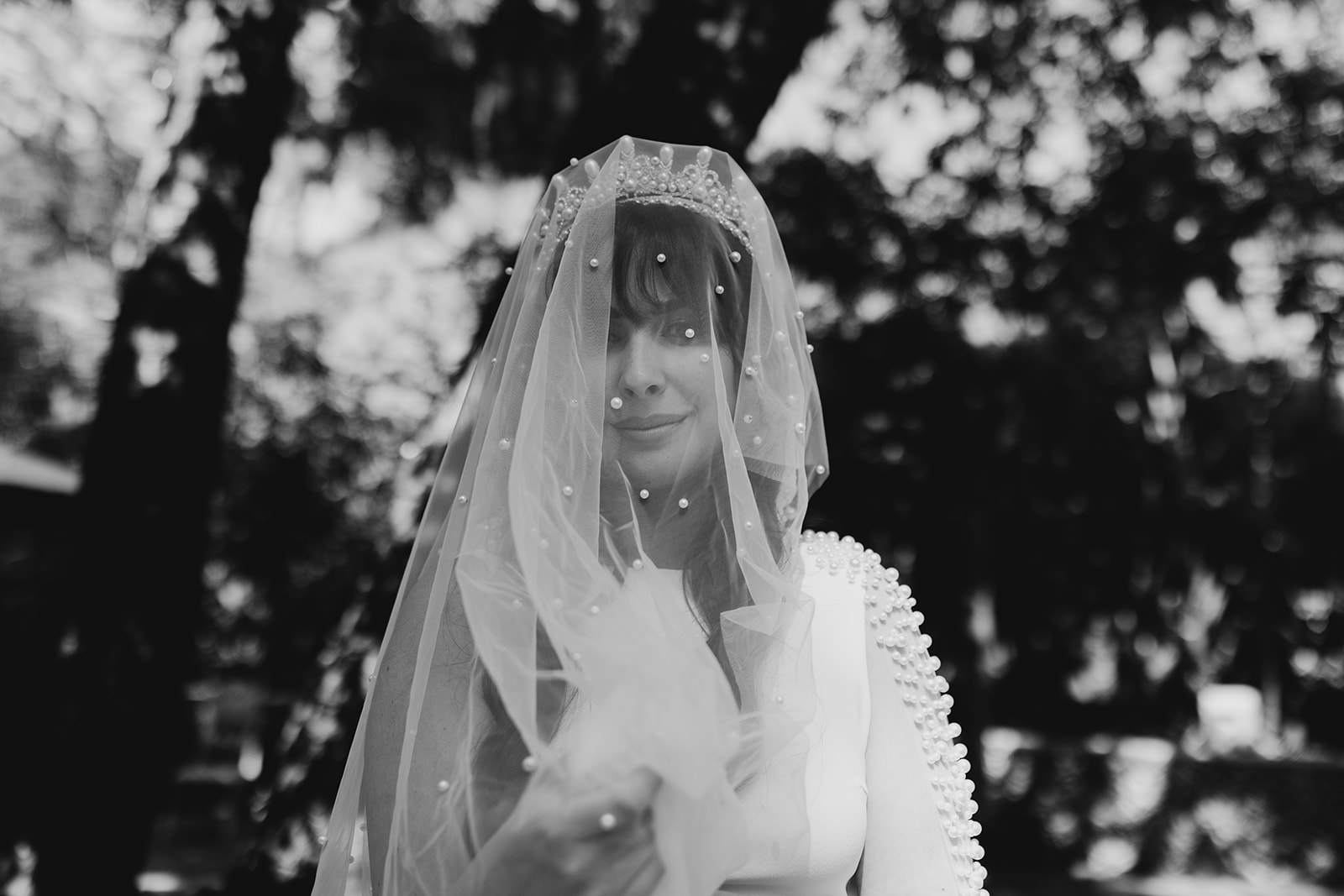 black and white photo of bride wearing a crown and beaded veil