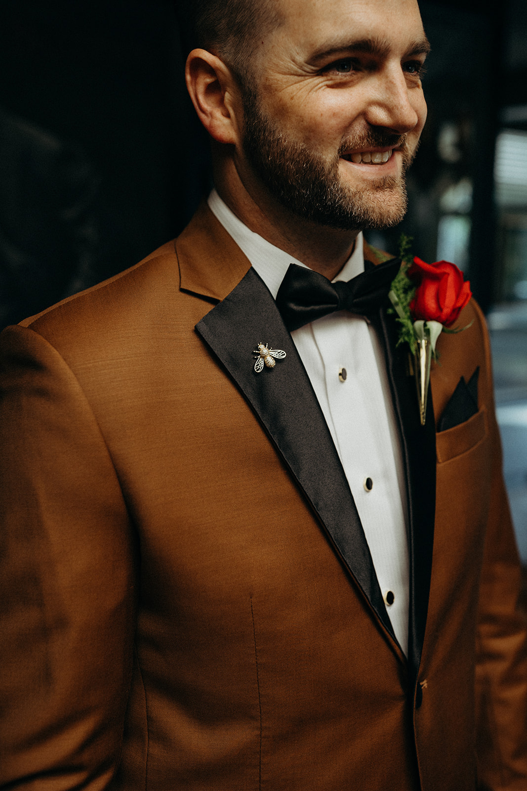 groom wearing a brown tuxedo