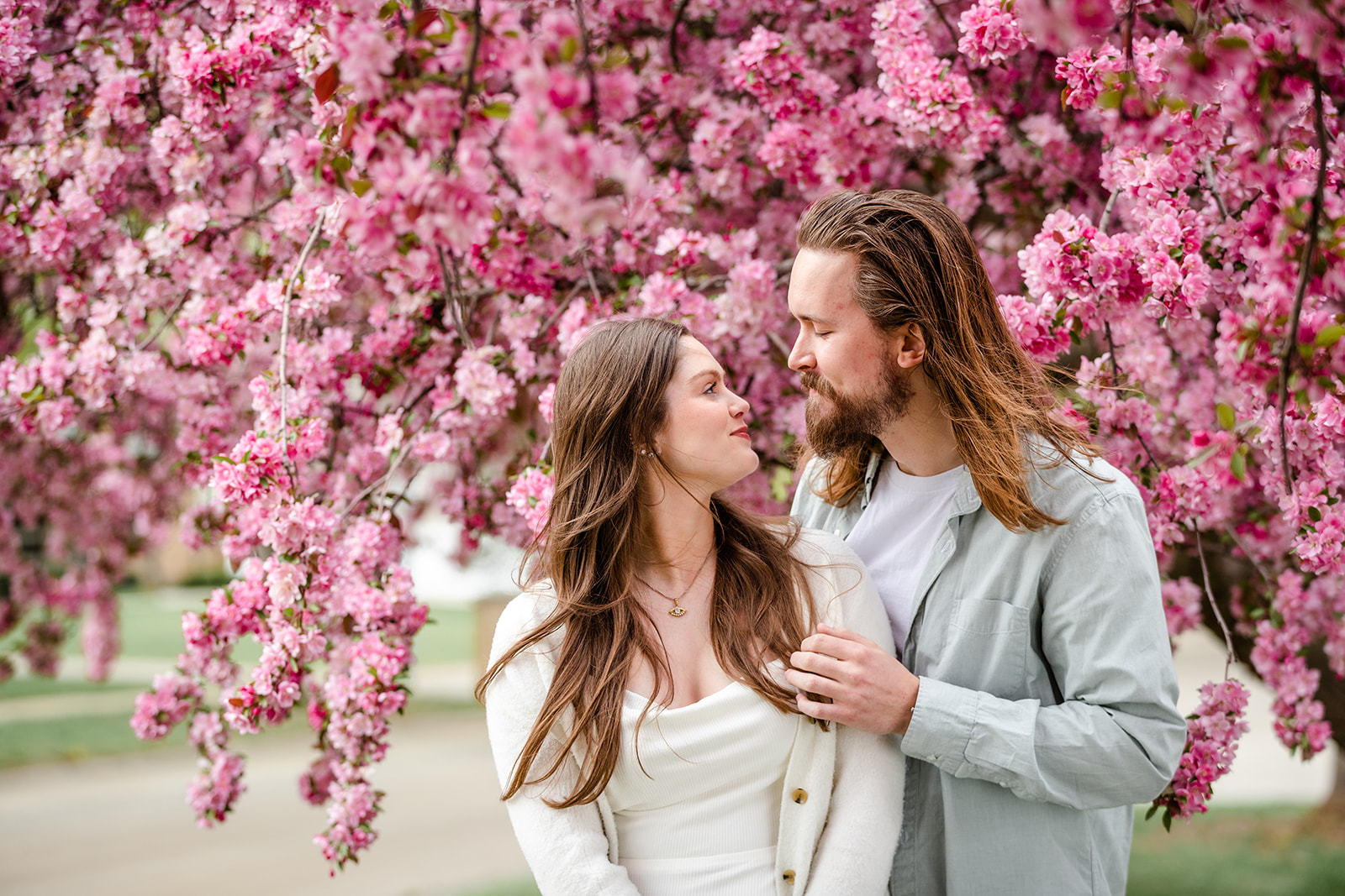 Couple looking at each other in front of purple tree