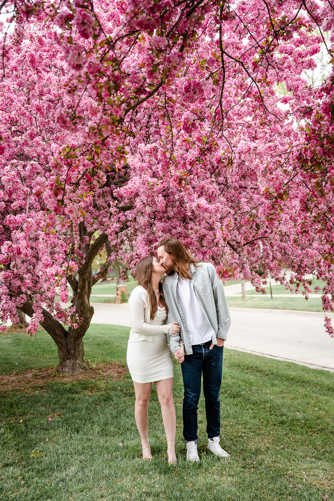 Full body crop of couple by blooming tree