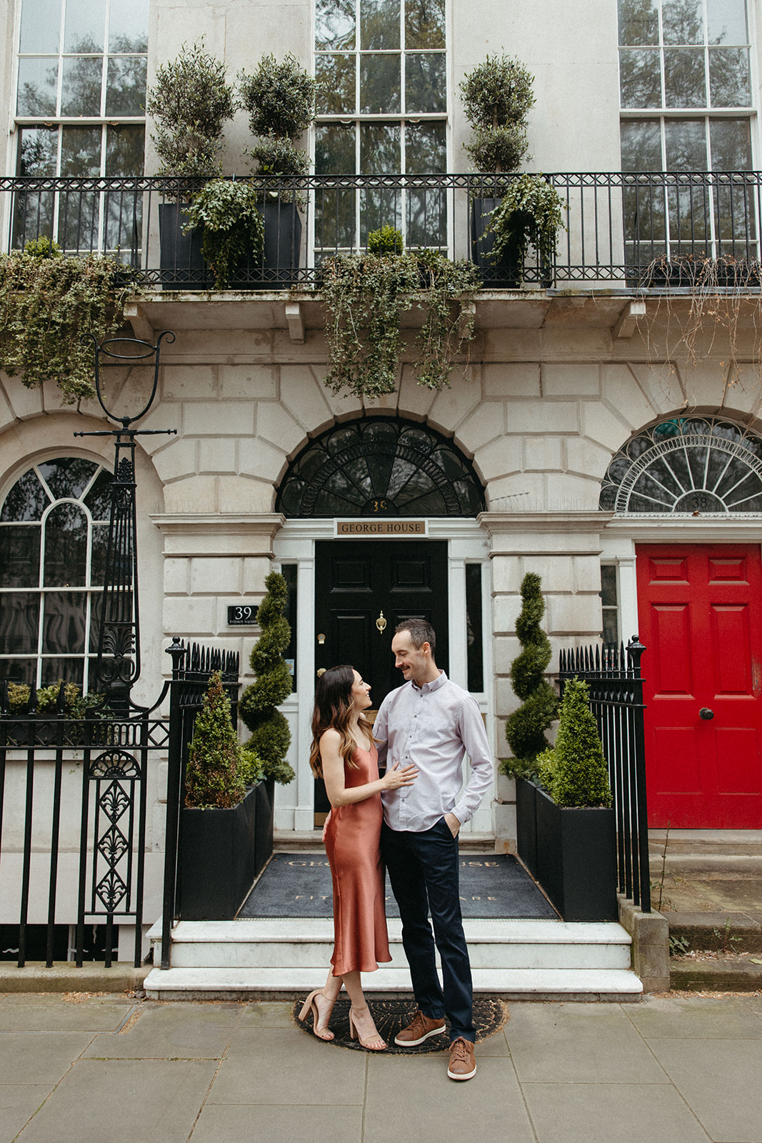 A luxury engagement session couple poses in front of George House in London, England. 