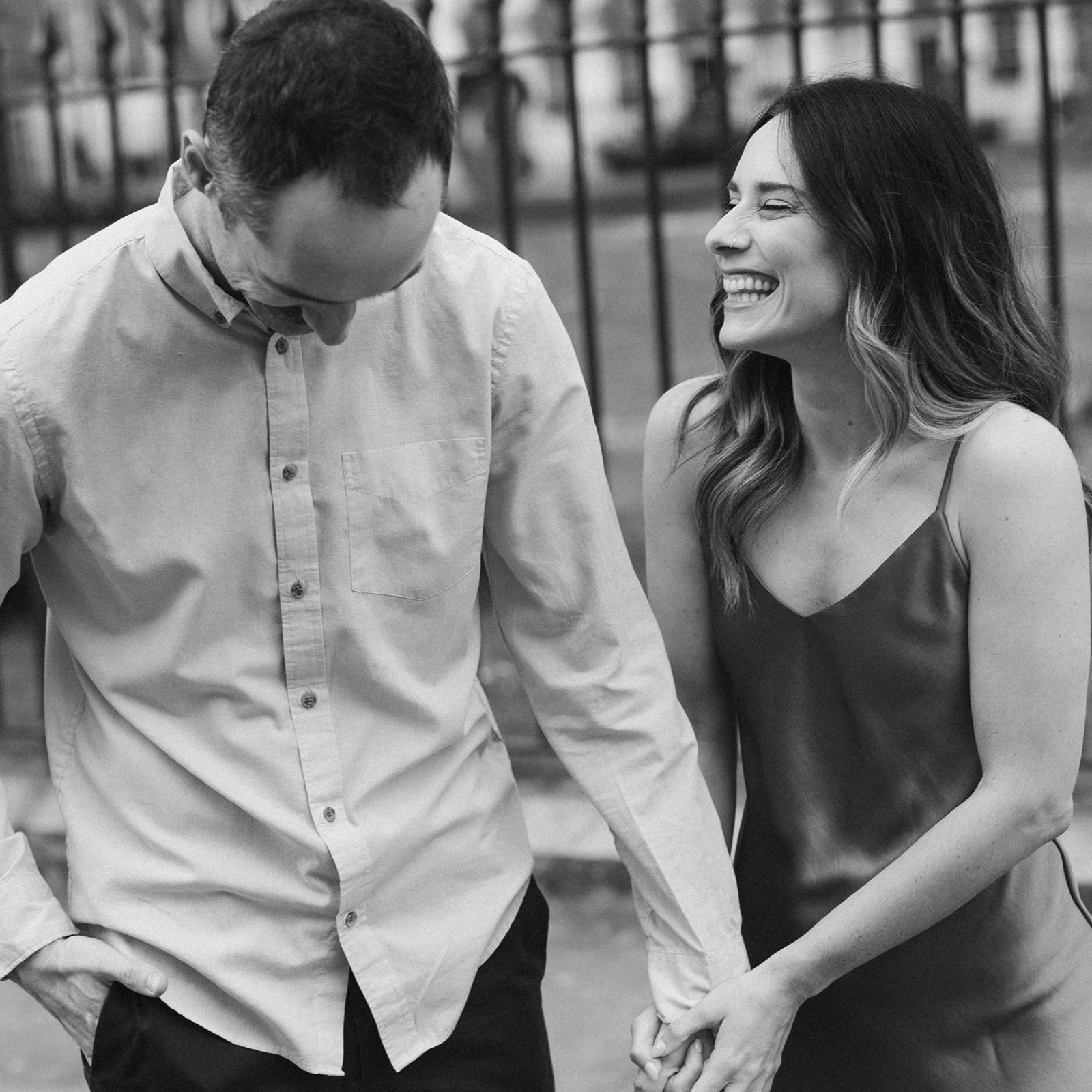 A couple holds hands posing for candid engagement photos during an old money aesthetic engagement session in London. 