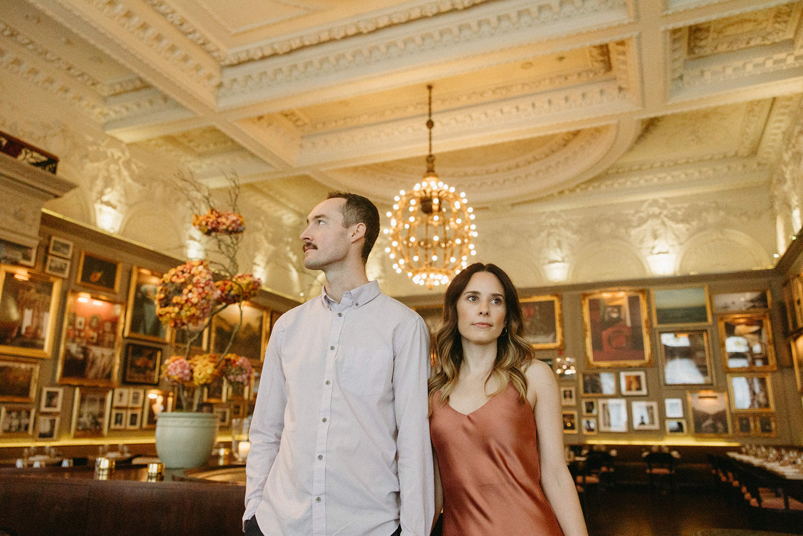 A couple stands in the middle of Berner’s Tavern at the London Edition Hotel for their city engagement session. 