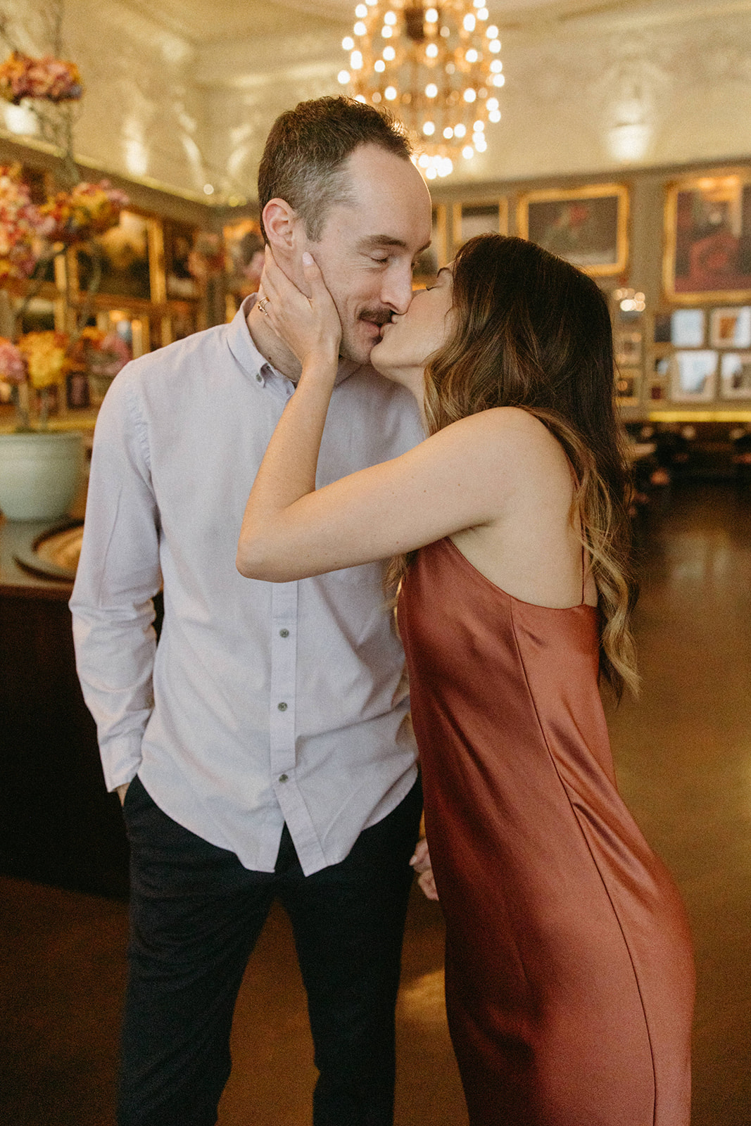 A couple shares a kiss in Berner's Tavern in London, England, during their romantic restaurant engagement session. 