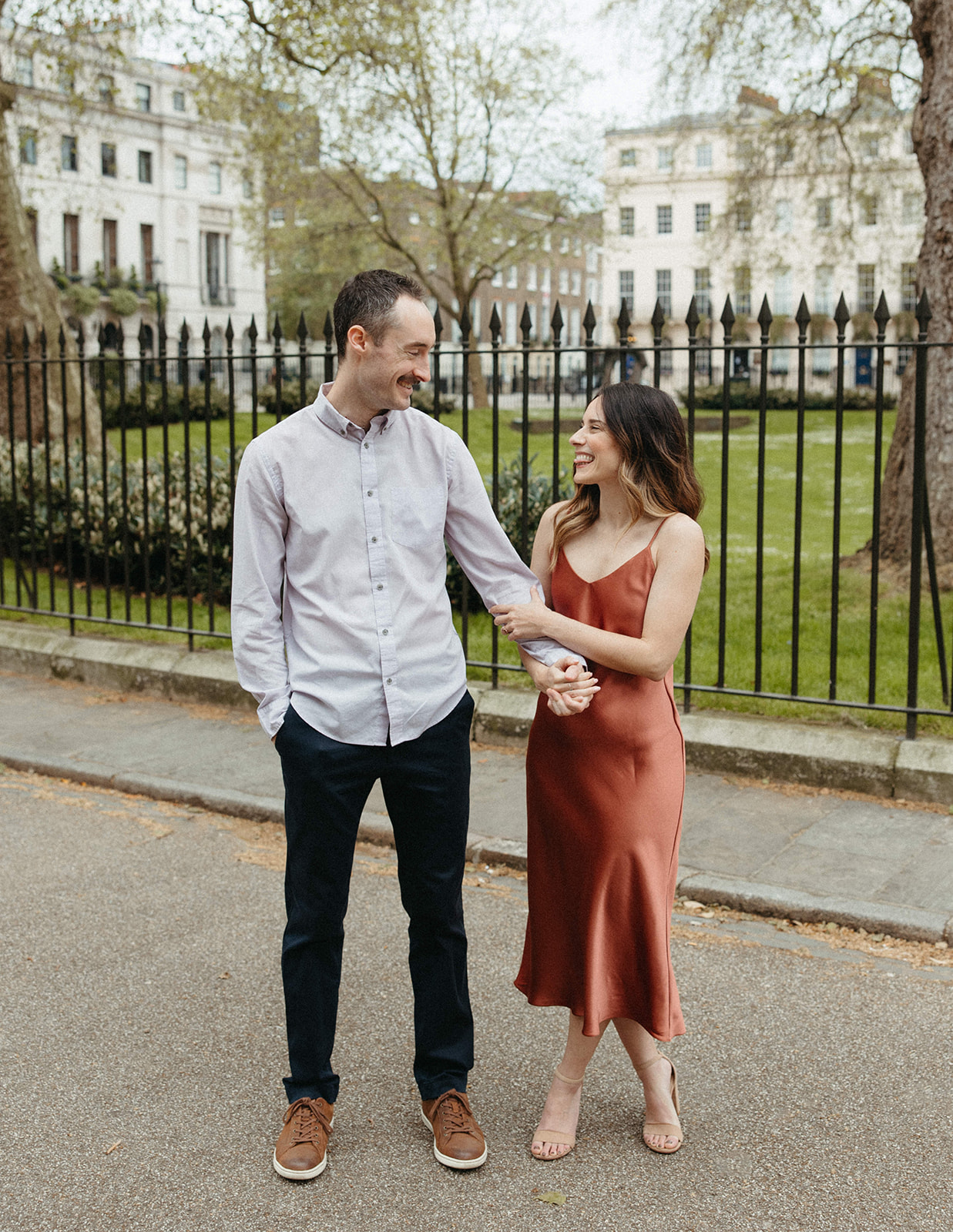 A man and his fiancée hold hands tightly during their engagement session in London.