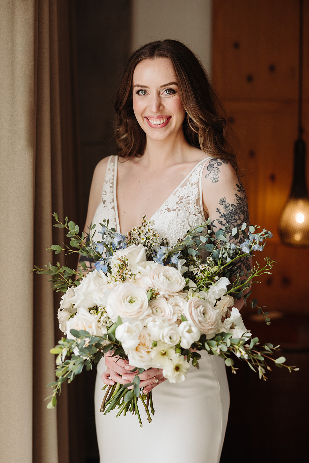 Bride portrait with her lace bodice wedding dress and wedding bouquet