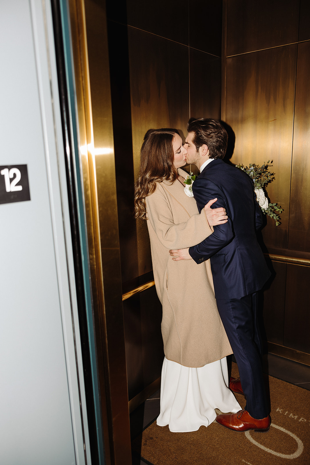 Bride and groom kissing in an elevator