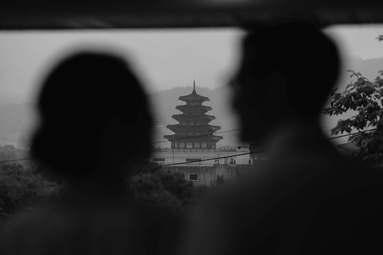 A bride and groom standing in front of an outdoor pagoda on their wedding day.