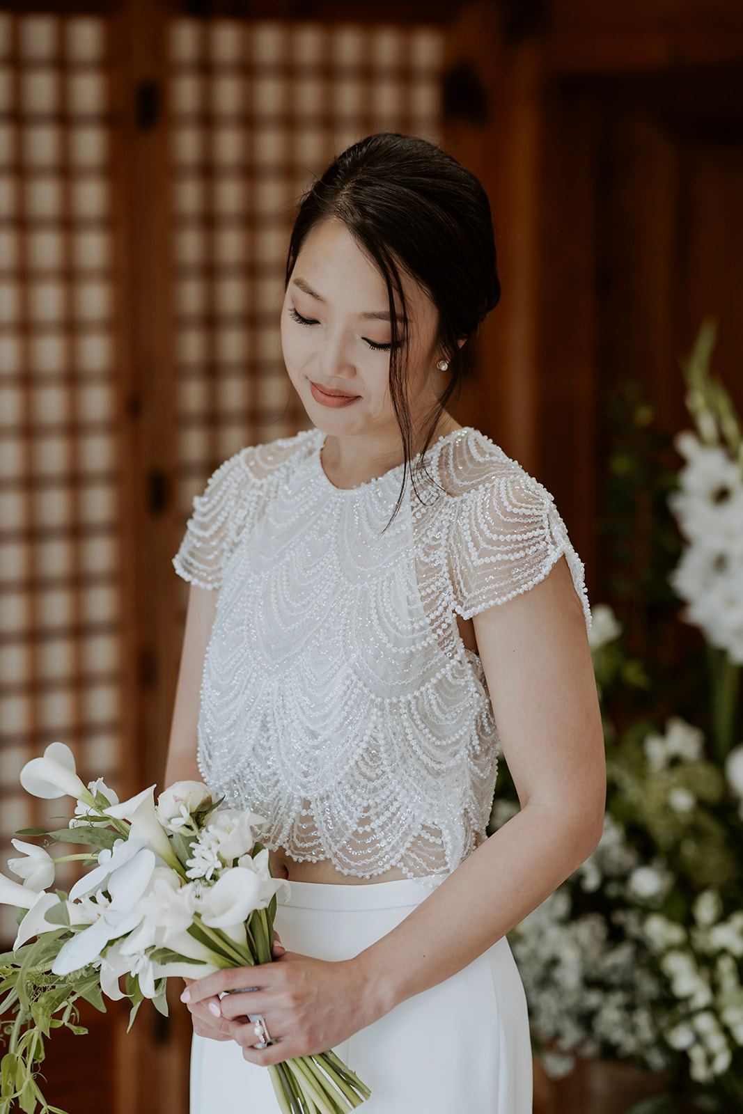 A bride holding a bouquet of white flowers on her wedding day.