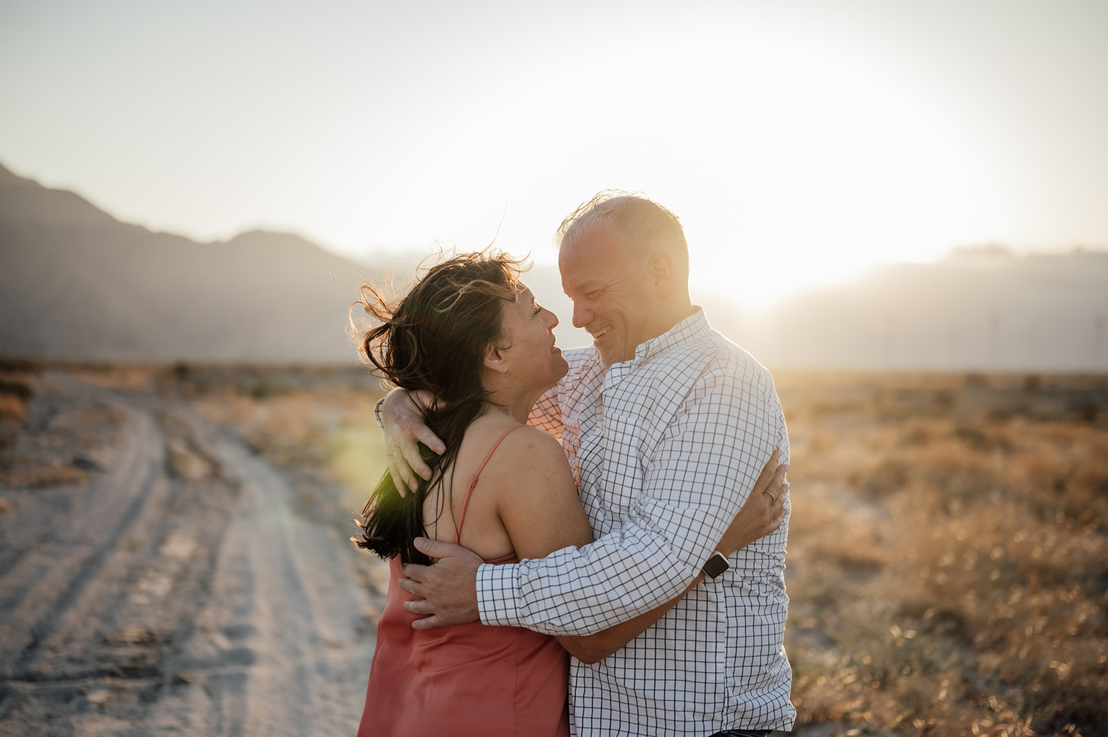 Couple staring into each other's eyes in front of a windmill farm in Palm Springs California.