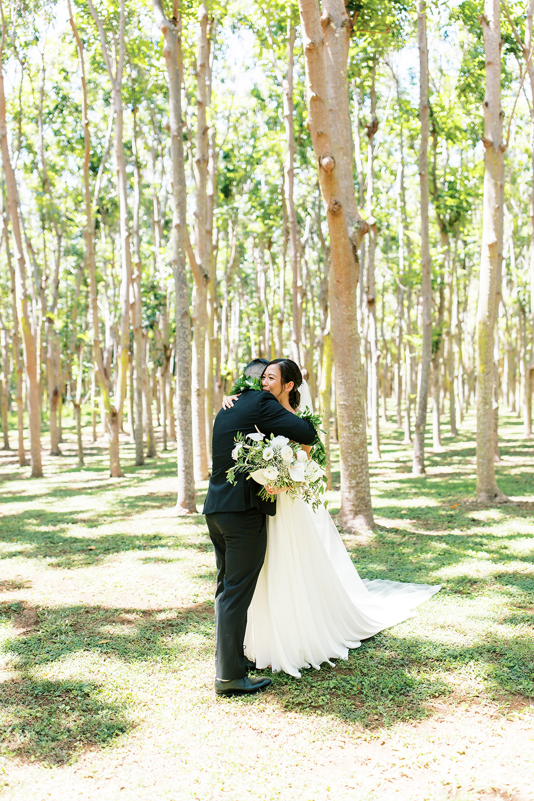 Bride and groom embracing in Wedding at Na ‘Āina Kai Botanical Gardens captured by Oahu Wedding Photographer Megan Moura