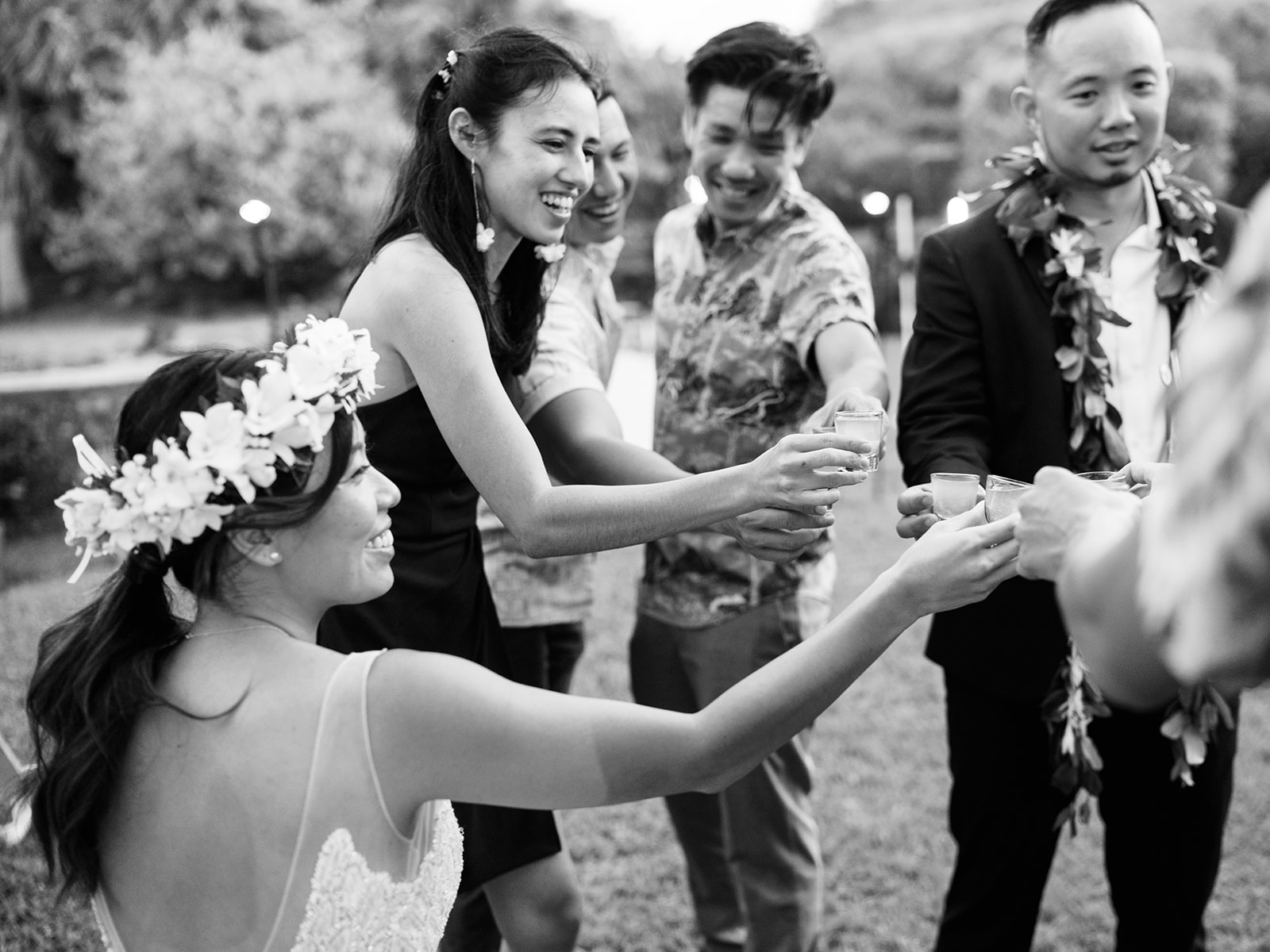 A group of joyful people toasting at a Wedding at Na ‘Āina Kai Botanical Gardens captured by Oahu Wedding Photographer