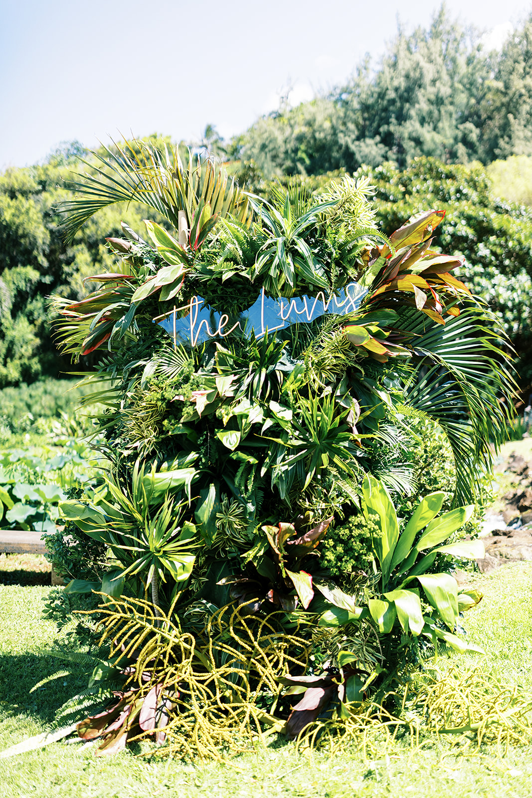 A lush, tropical foliage arrangement with a sign saying "the menu" nestled within the greenery.