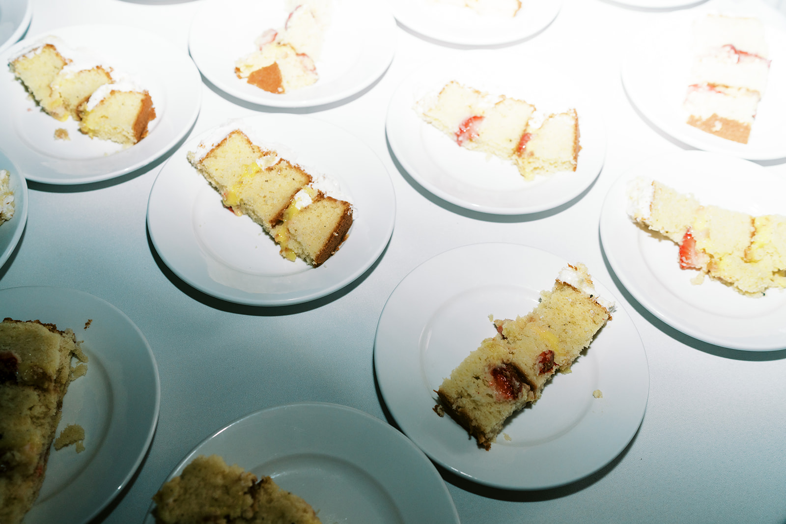 Plates of sliced cake arranged on a surface Wedding at Na ‘Āina Kai Botanical Gardens