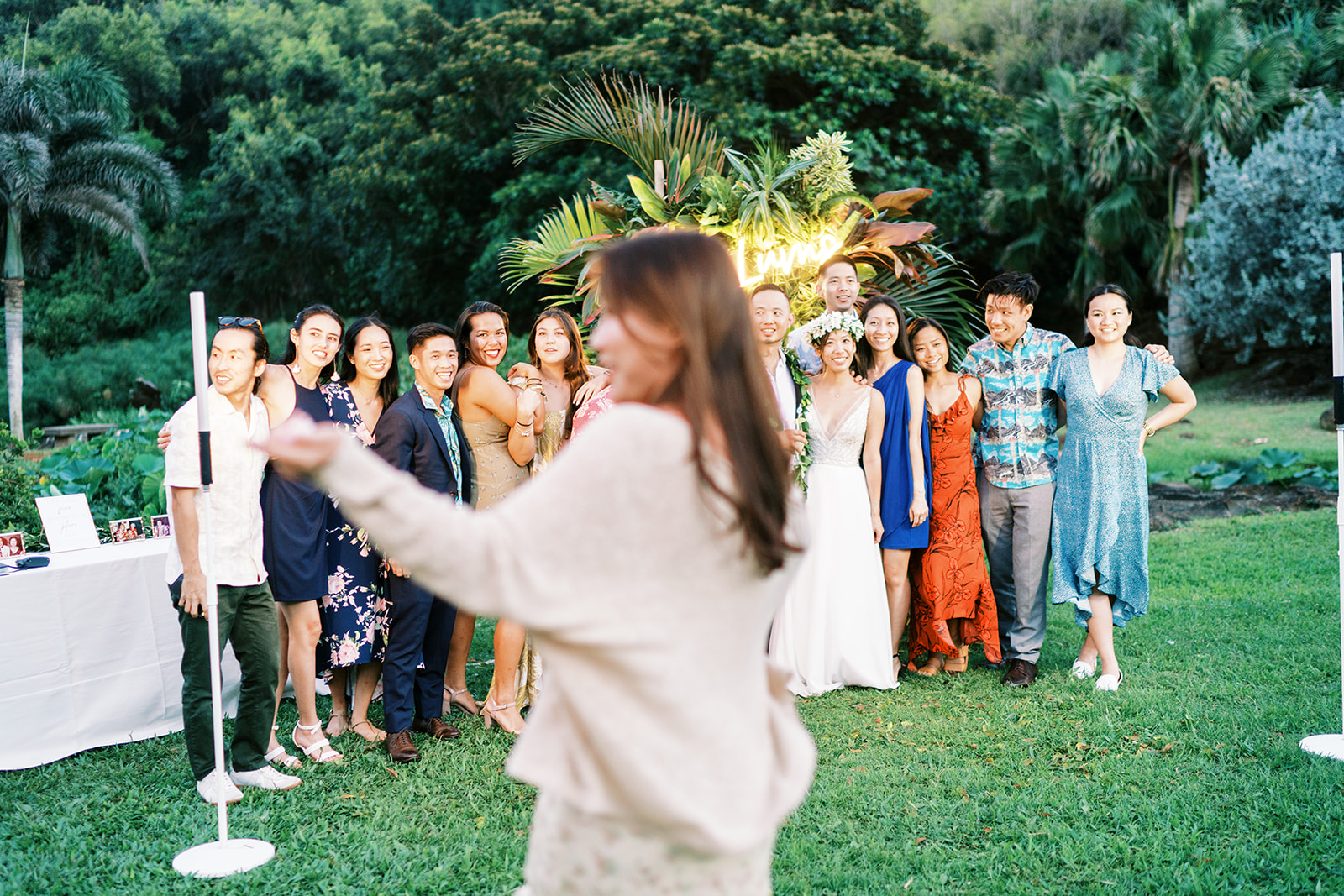 Woman gesturing towards a group of people at a Wedding at Na ‘Āina Kai Botanical Gardens