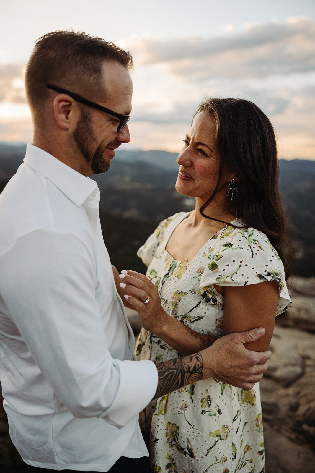 Man and woman smiling during sunset engagement session