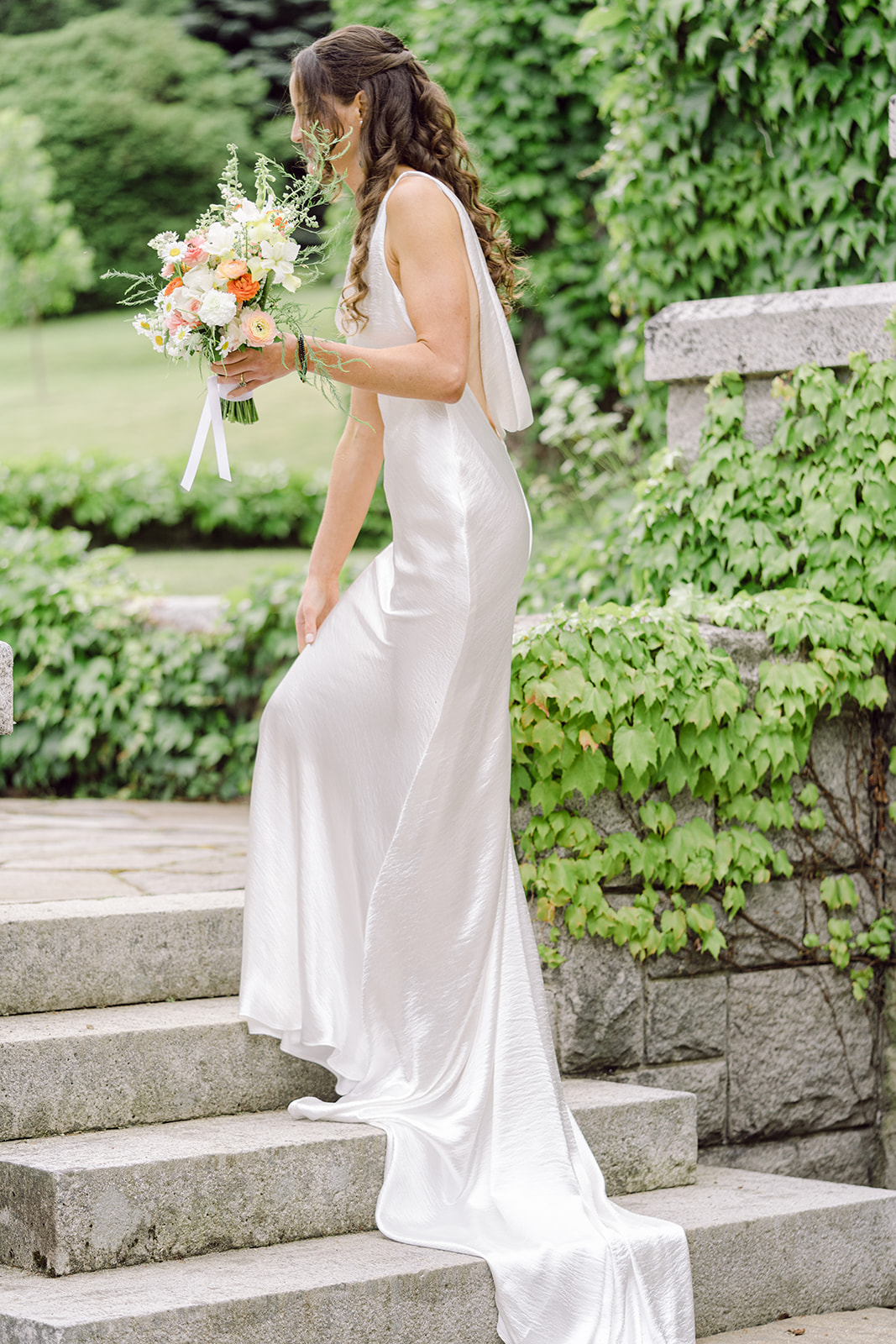 Bride in Newhite Bridal on the steps at a Blaylock Mansion wedding in Nelson BC