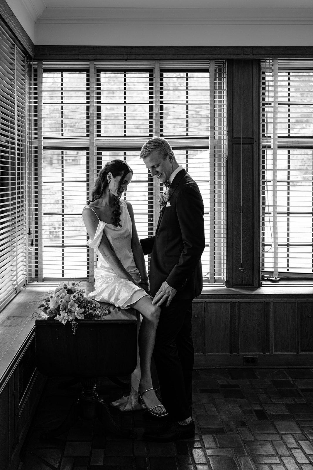 Bride and groom share a moment together in the solarium at their Blaylock Mansion wedding in Nelson BC