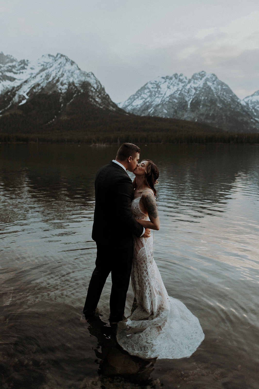 A wedding couple kissing in Leigh Lake in Grand Teton National Park near Jackson Hole