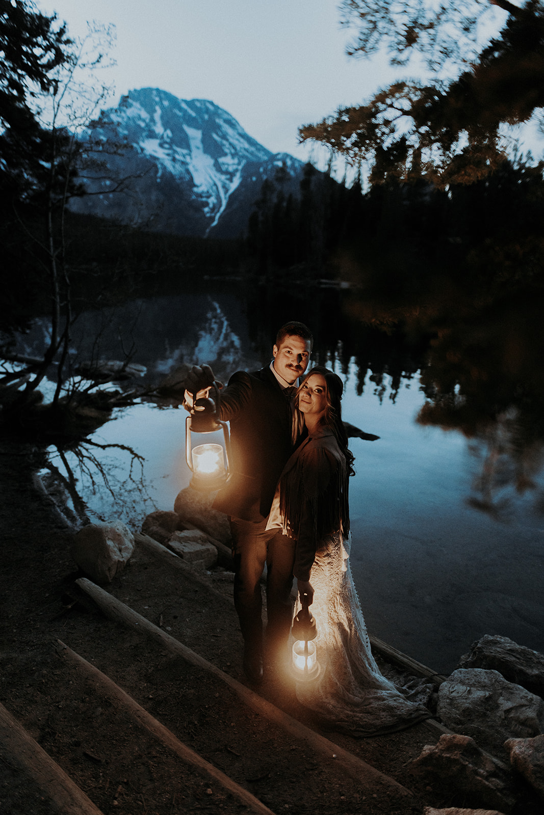 A boho wedding couple with lanterns by Lake Leigh in Grand Teton National Park