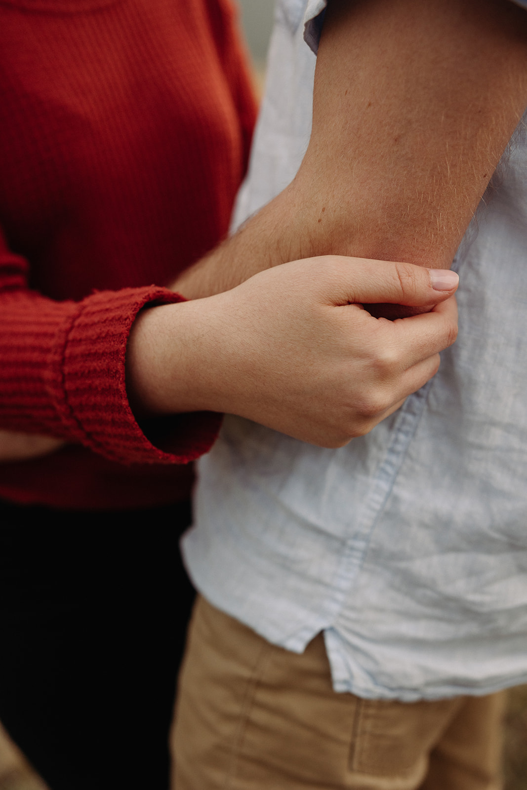 A close up of a woman's hand holding a man's arm