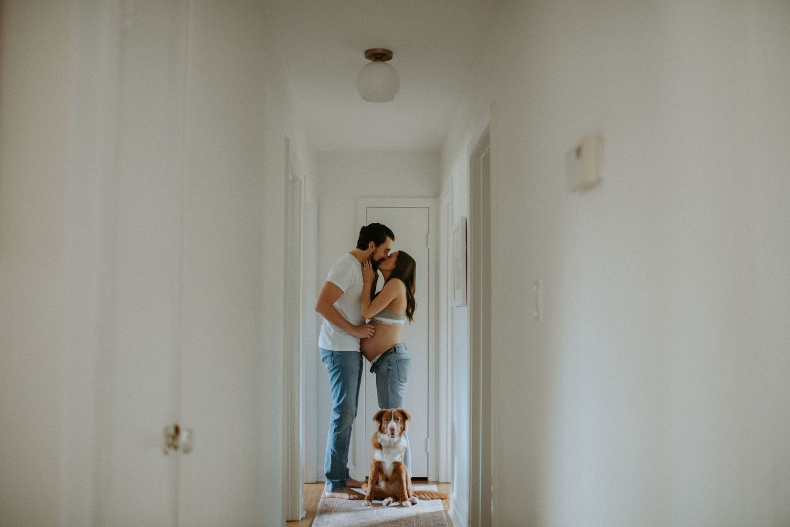 Expecting couple cozies up in their hallway during their at home maternity photosession