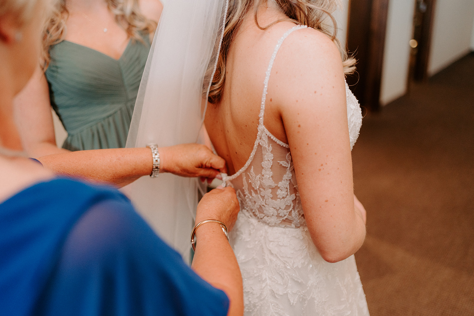 Bride getting buttoned into her dress.