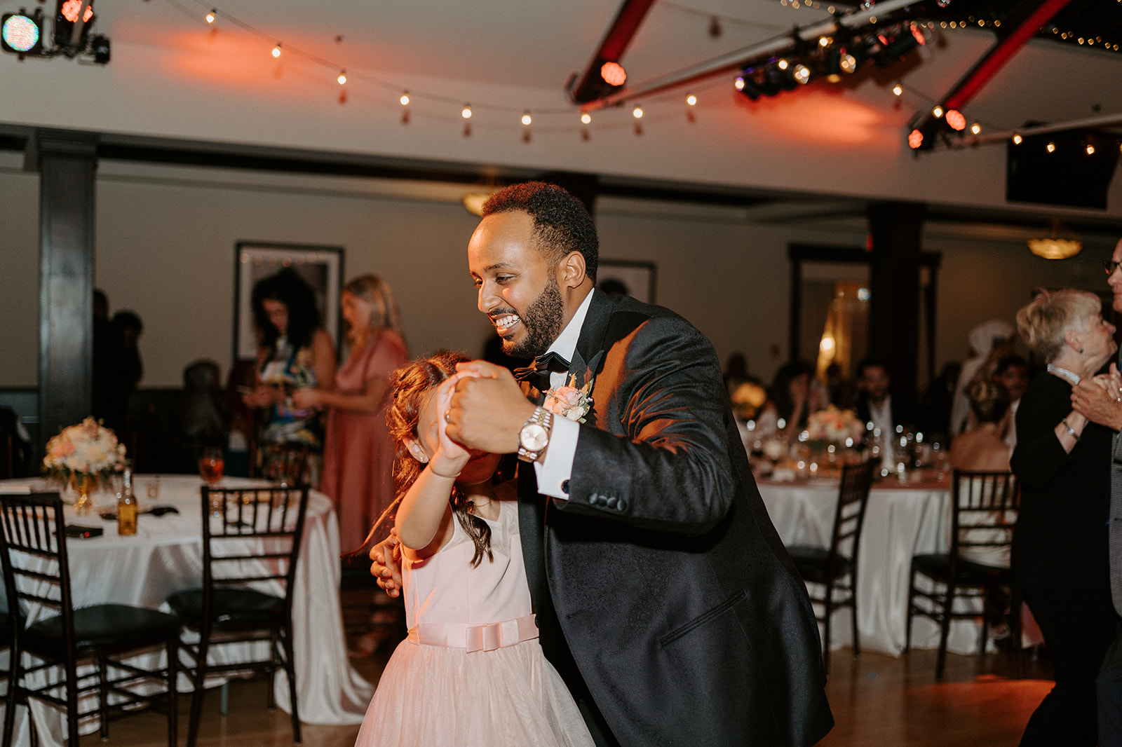 Groom dancing with a flower girl.